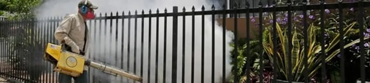 Mosquito control technician fogging a yard perimeter for mosquito reduction in San Antonio, TX